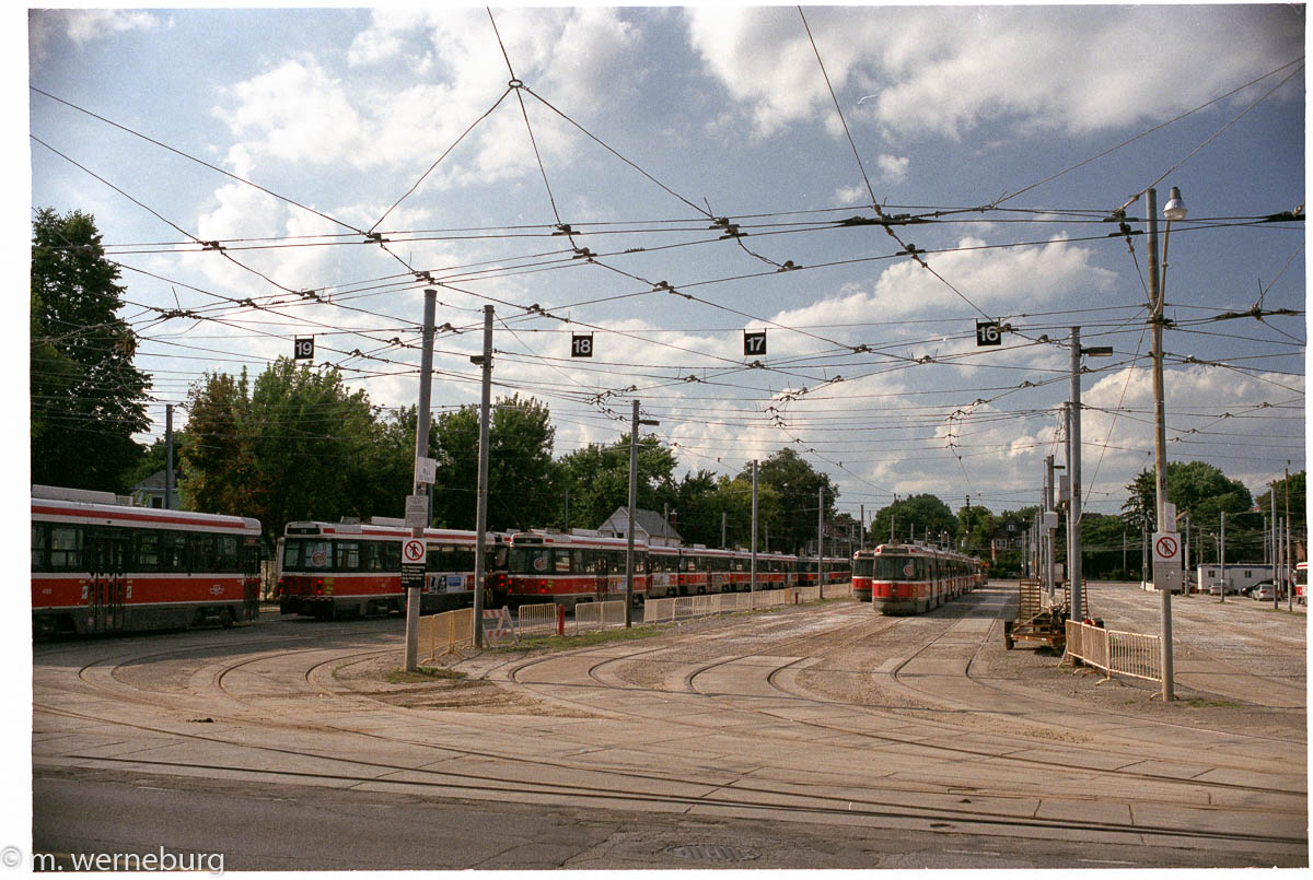 a web of street car powerlines near a rail yard
