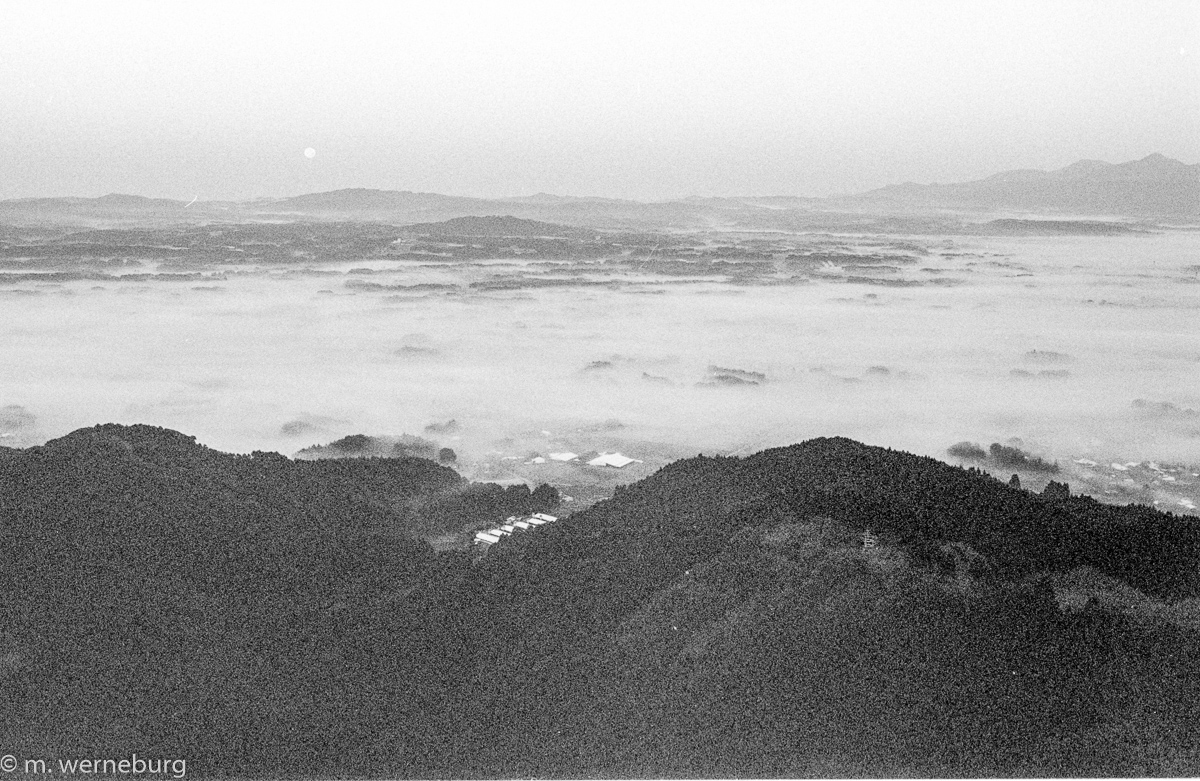 a sea of cloud and a setting moon